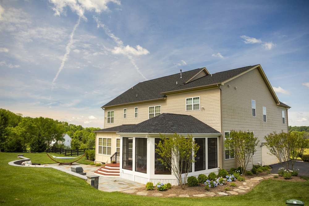 landscaping around enclosed porch with trees and hydrangea