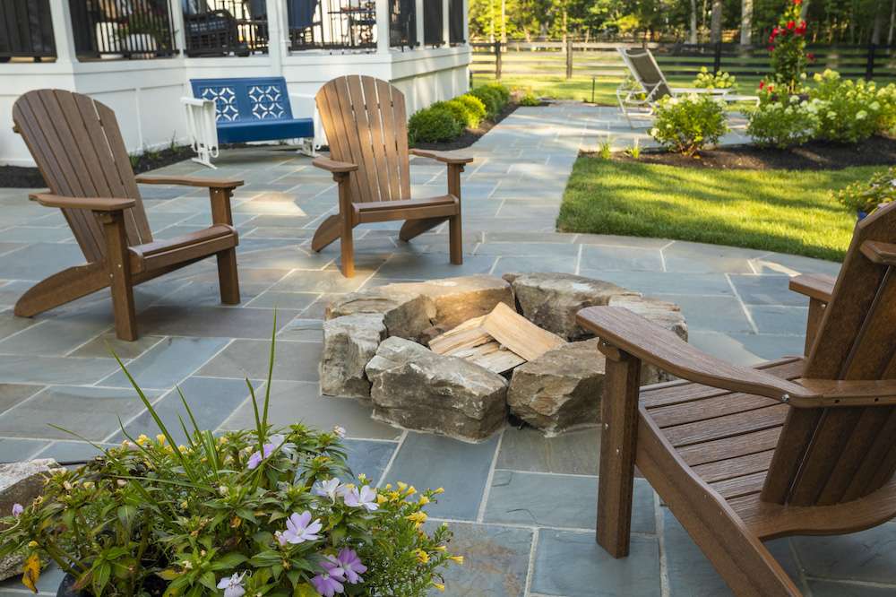 fire pit with wood and boulders on natural stone patio