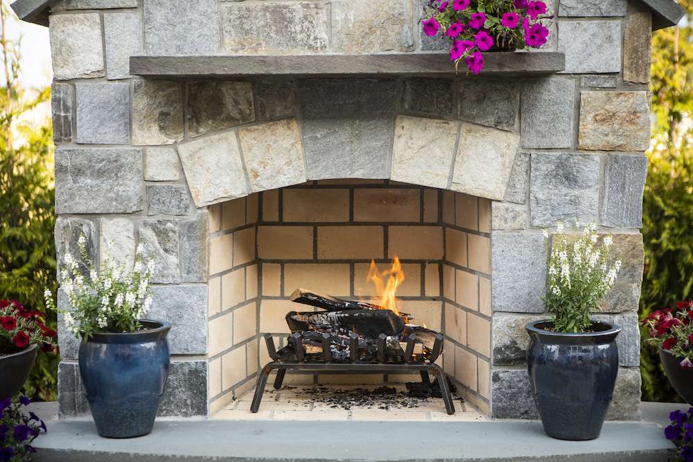 wood burns in natural outdoor fireplace