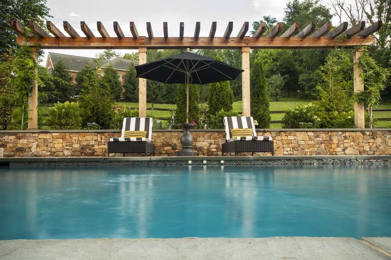 pergola and umbrella to provide shade near pool