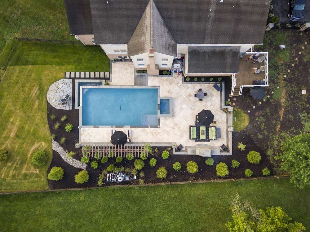 aerial photo of pool with patio and flagstone seating area