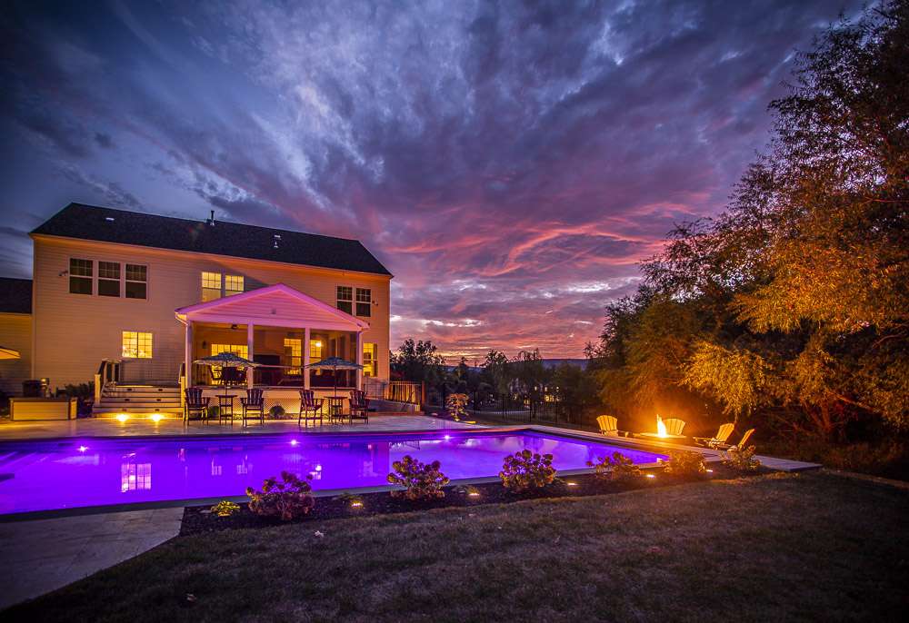 large pool with night lighting and firepit
