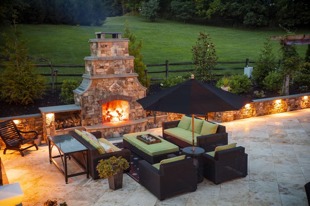 Outdoor fireplace with seating wall and lighting