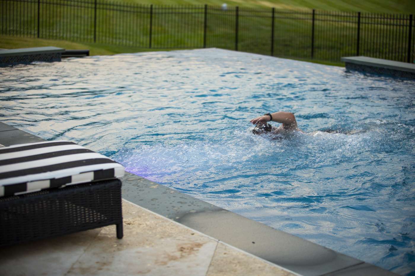 man swimming in pool with swim jets