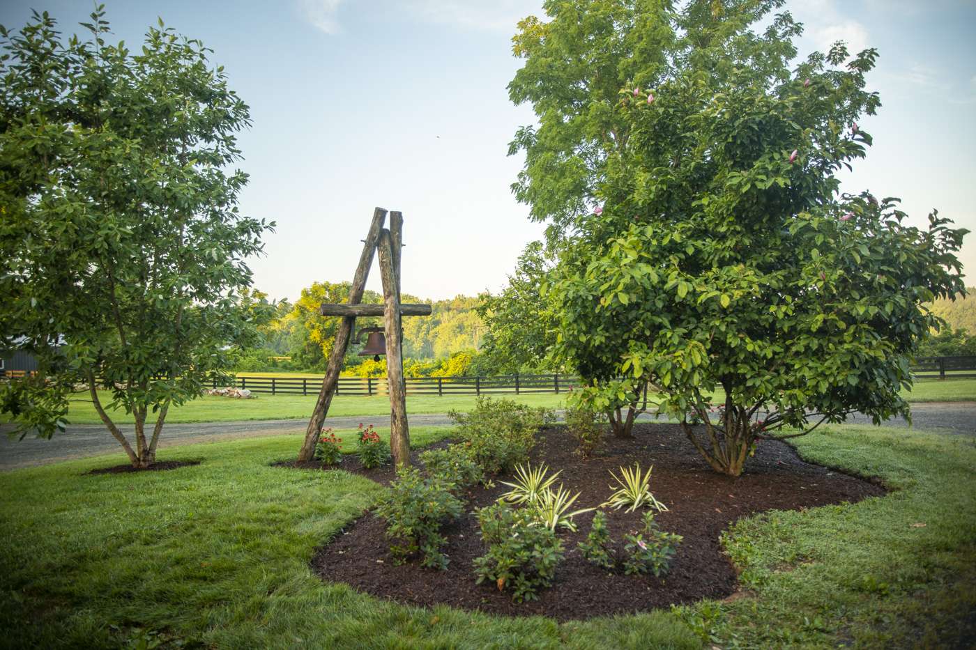 landscape bed with plantings and bell