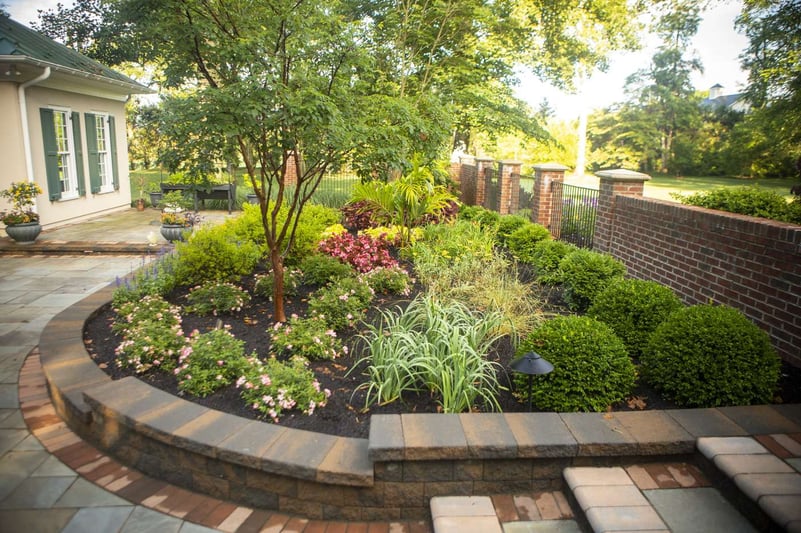 landscape bed with plantings near fence and patio