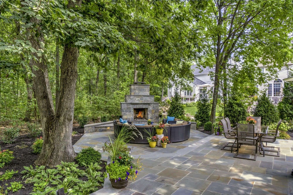 Private backyard patio with fireplace and trees
