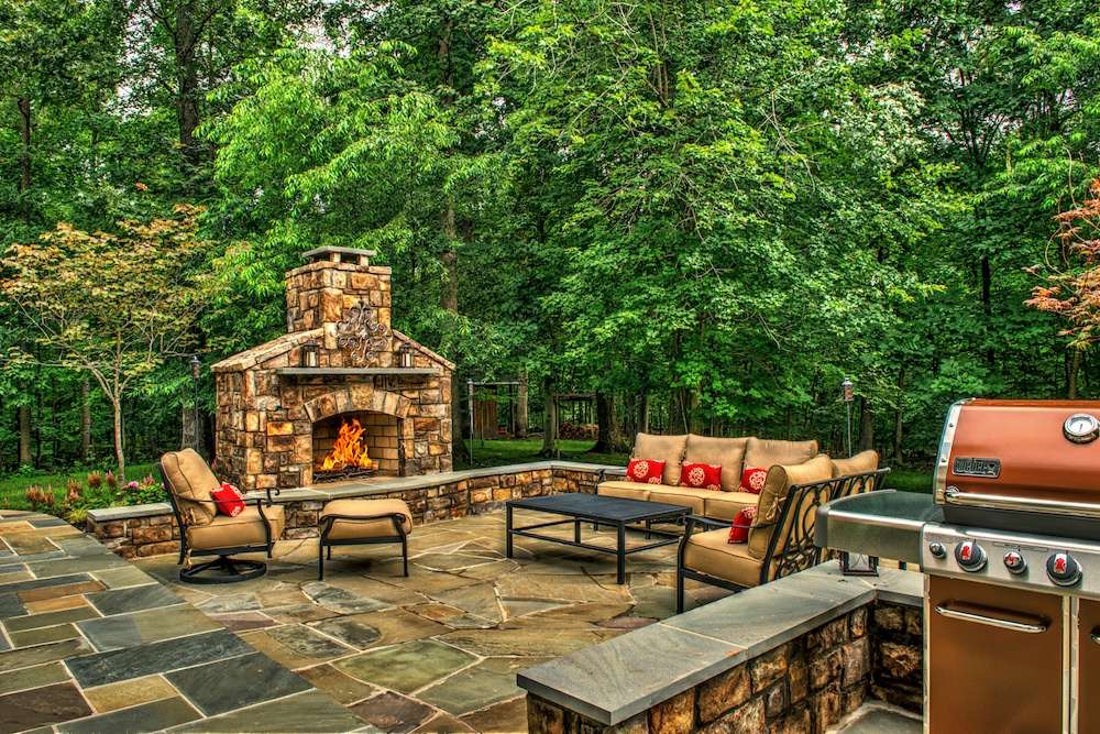 Outdoor fireplace with natural stone patio and grill