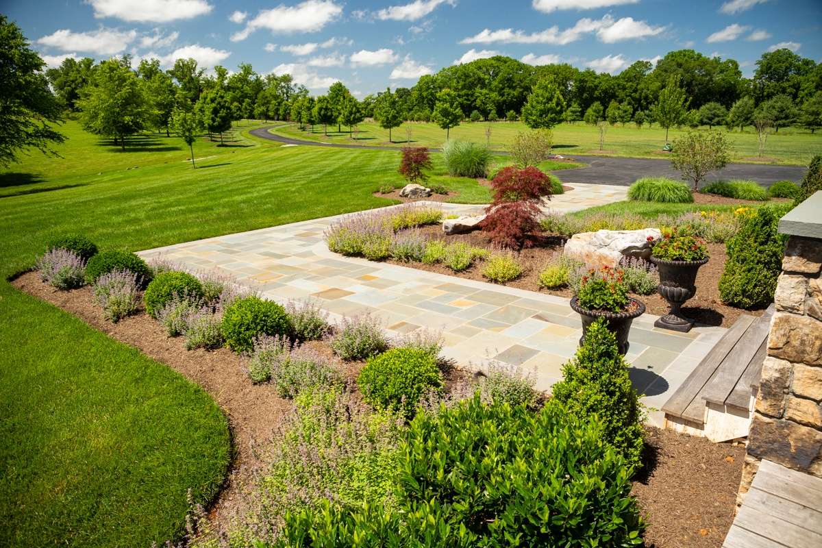 green grass and plantings with natural stone walkway