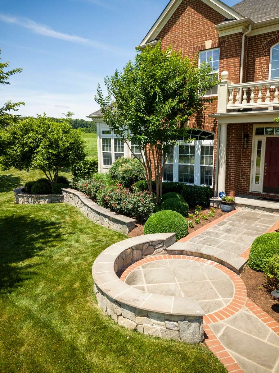 front walkway of home with retaining walls and plantings