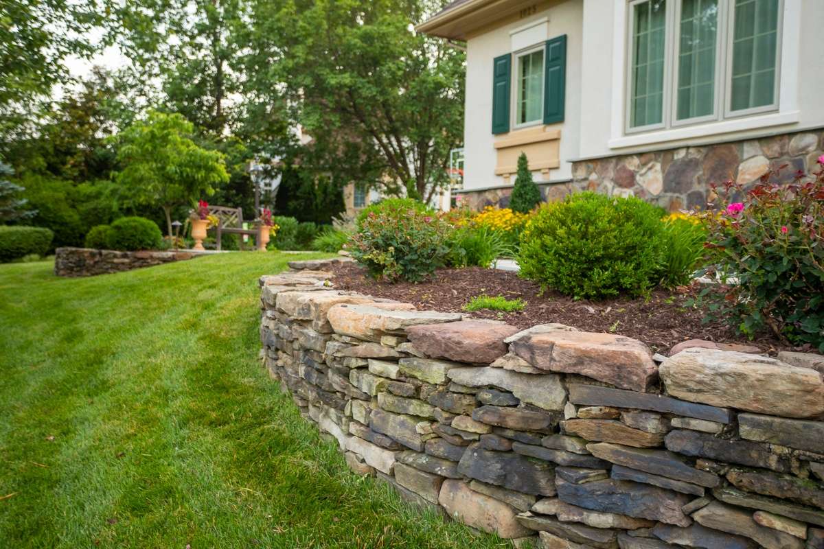 landscape bed with small accent wall at front of home