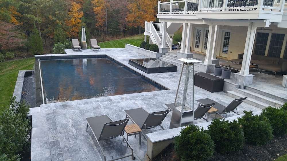 infinity pool with natural stone patio and hot tub