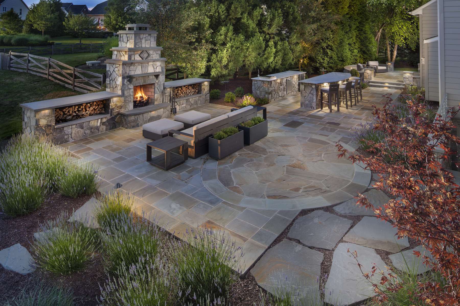 outdoor fireplace and patio with landscape lighting