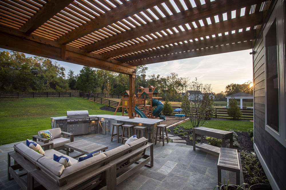 outdoor kitchen with seating area and playground 