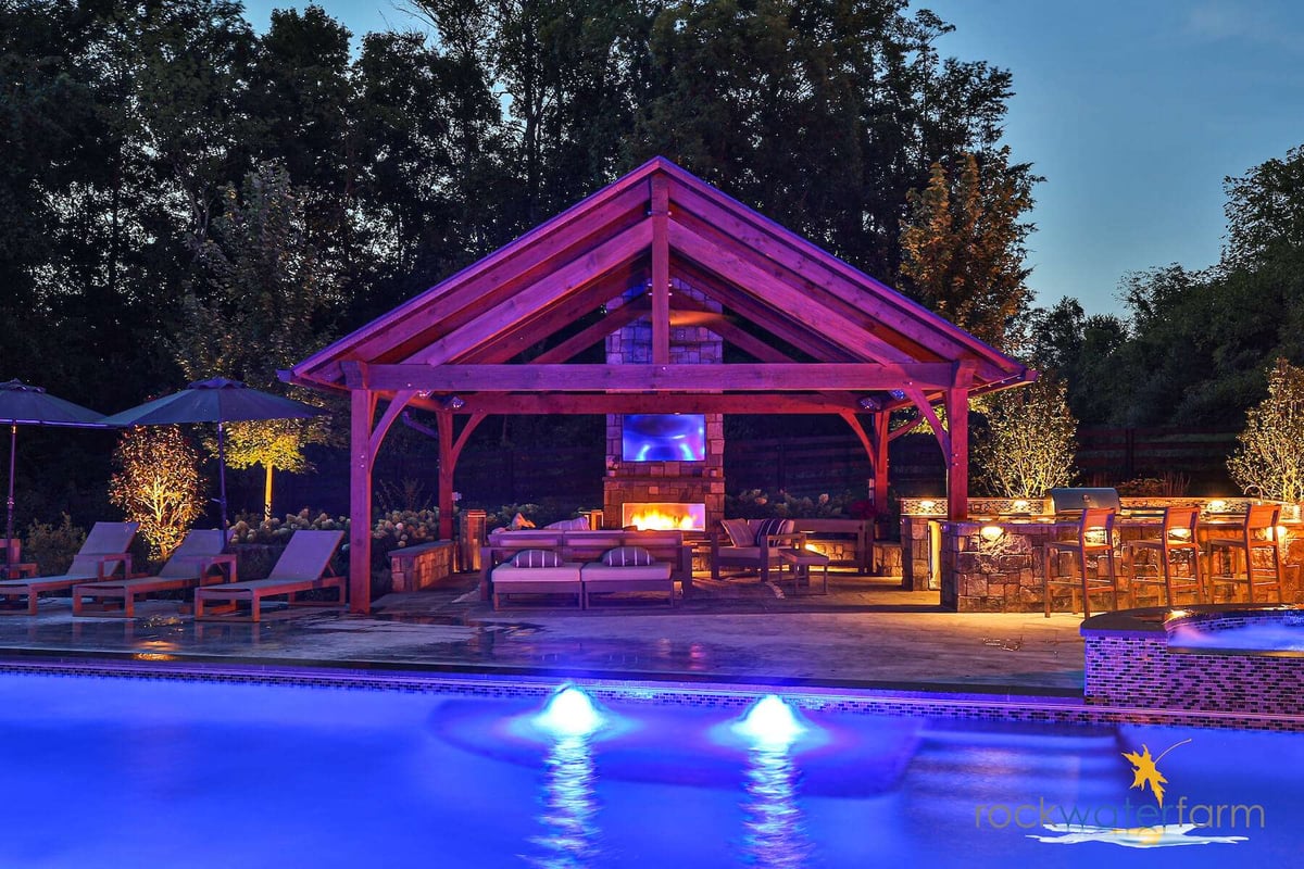 pavilion near pool with fireplace and television