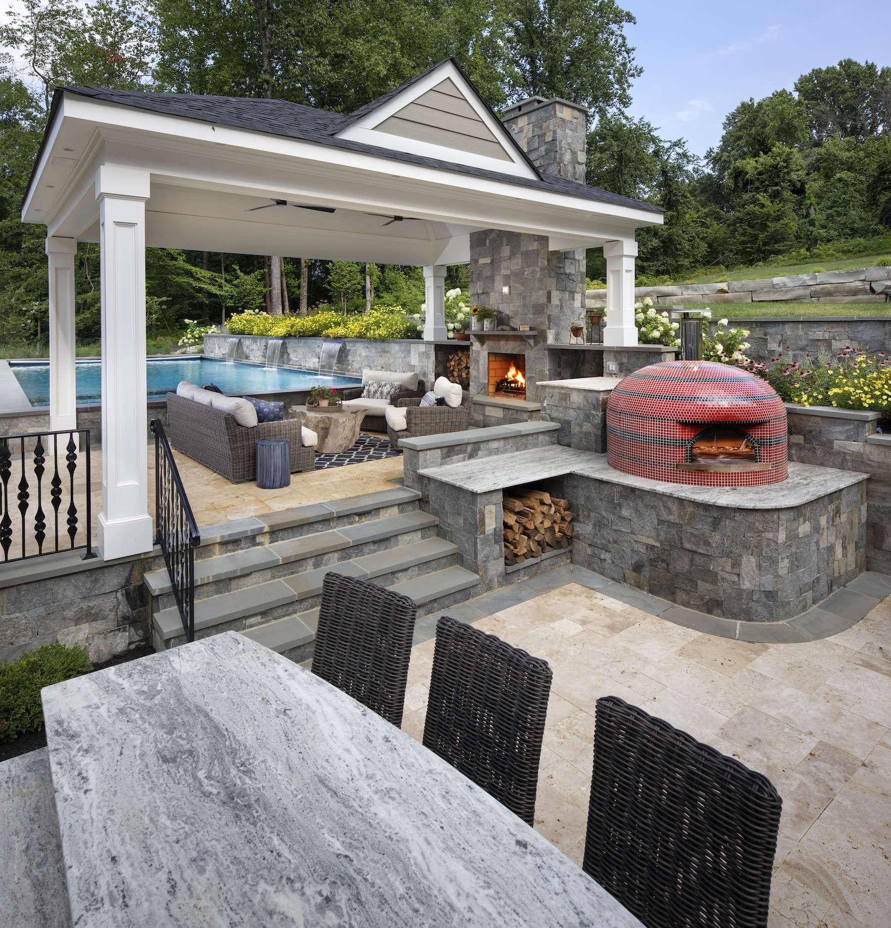 Pavillion and fireplace next to a pool