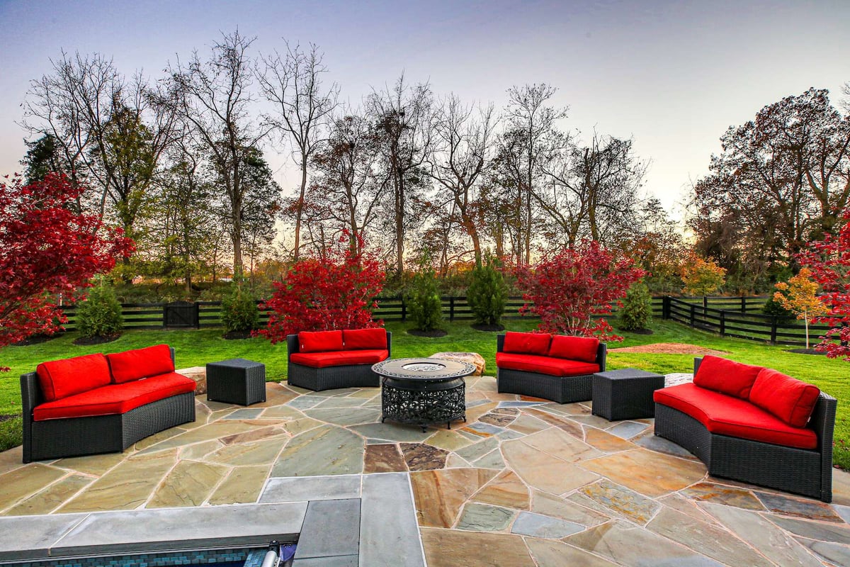 natural stone patio with red cushions on outdoor furniture