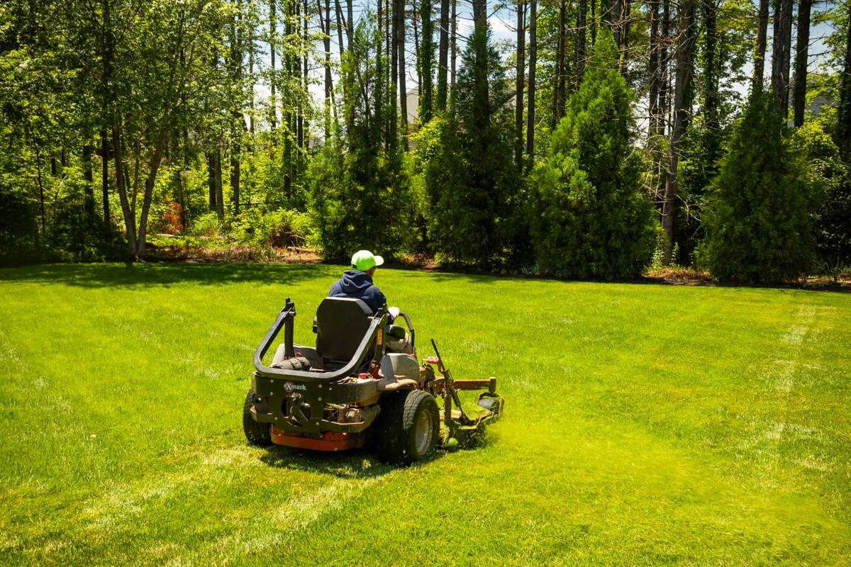 landscape maintenance crew mows lawn