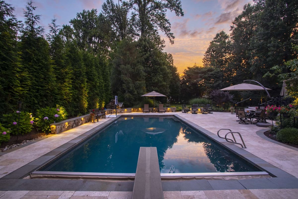 inground pool with diving board and basketball hoop