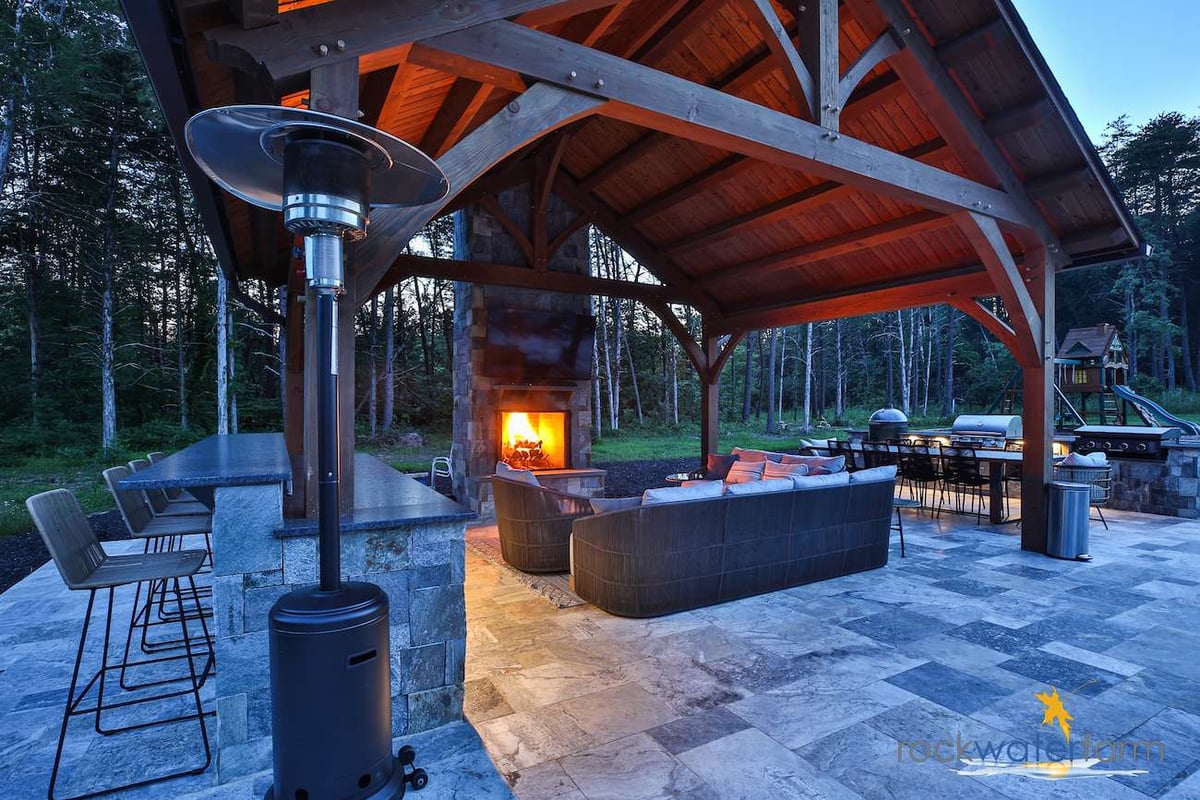 fireplace under pavilion with outdoor kitchen