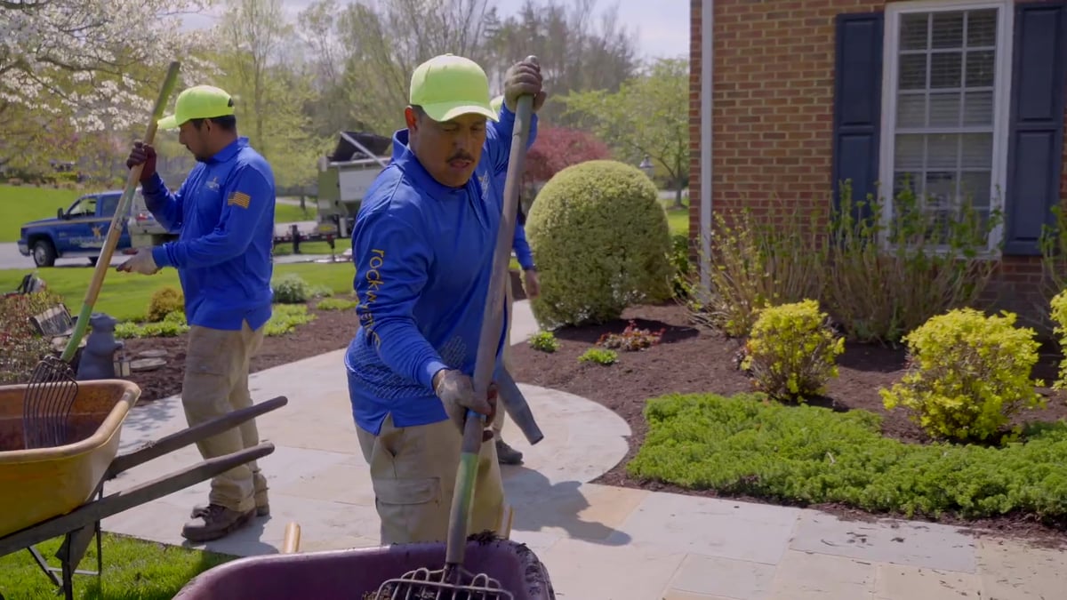 landscape maintenance team installs mulch into landscape beds