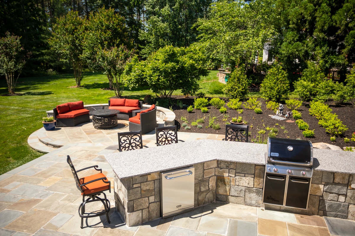 outdoor kitchen and firepit on flagstone patio