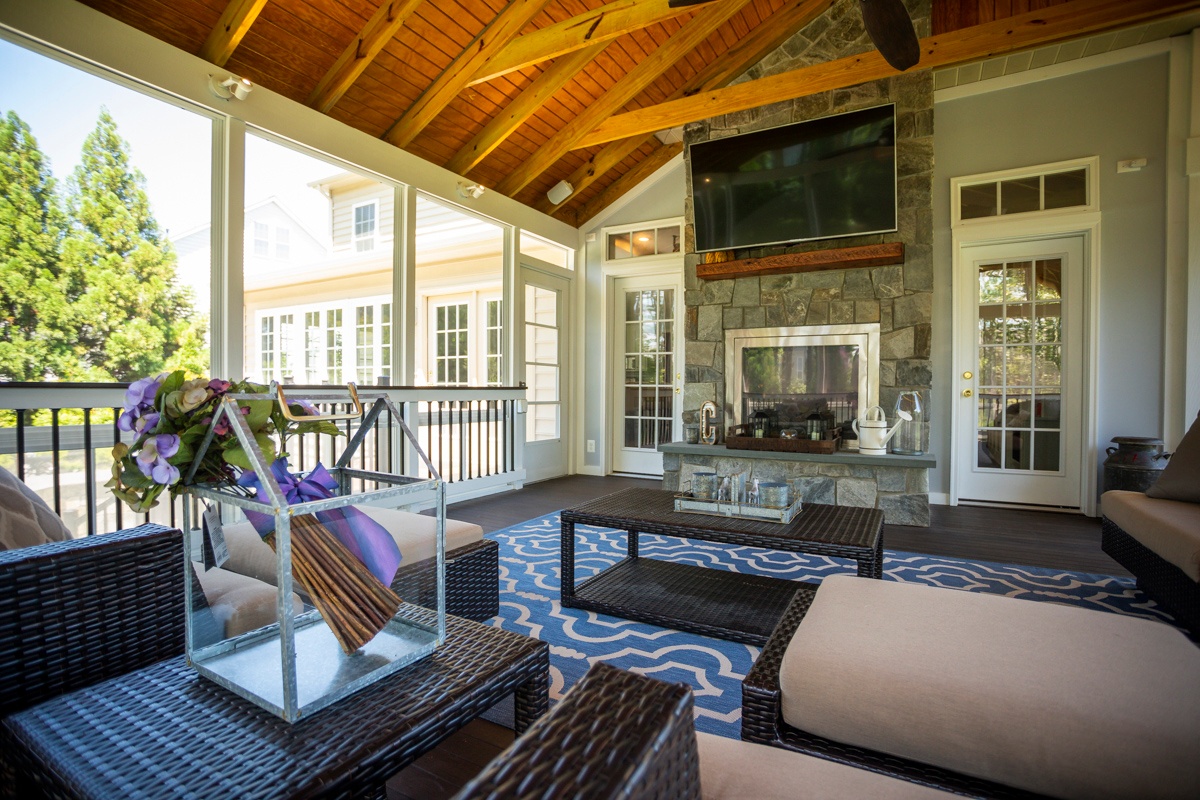 screened porch on deck with fireplace and television