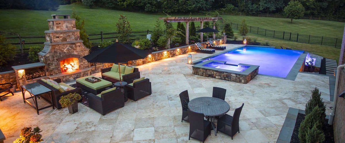 outdoor living area with fireplace and pool with lighting
