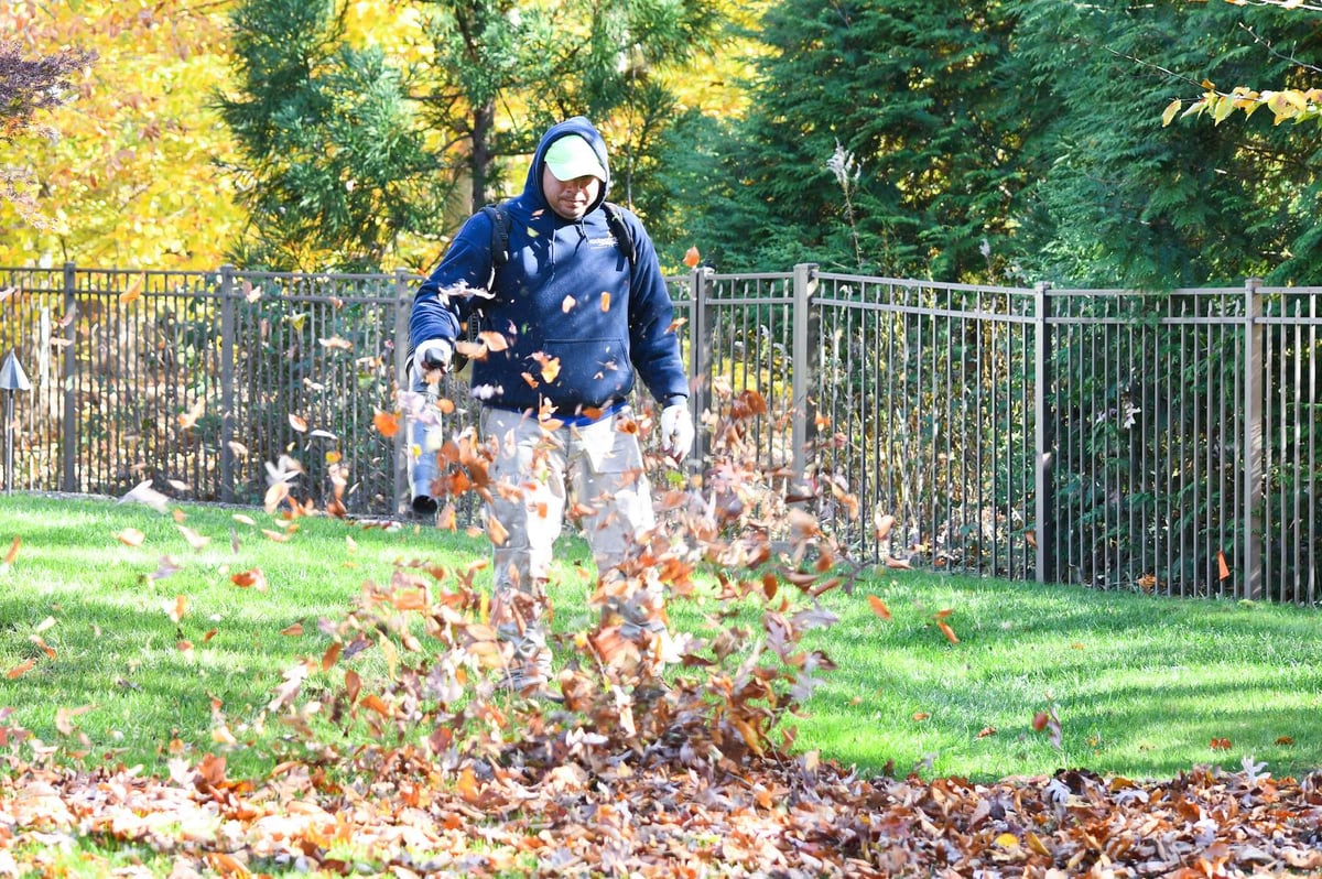 landscape maintenance team uses backpack blower to remove leaves