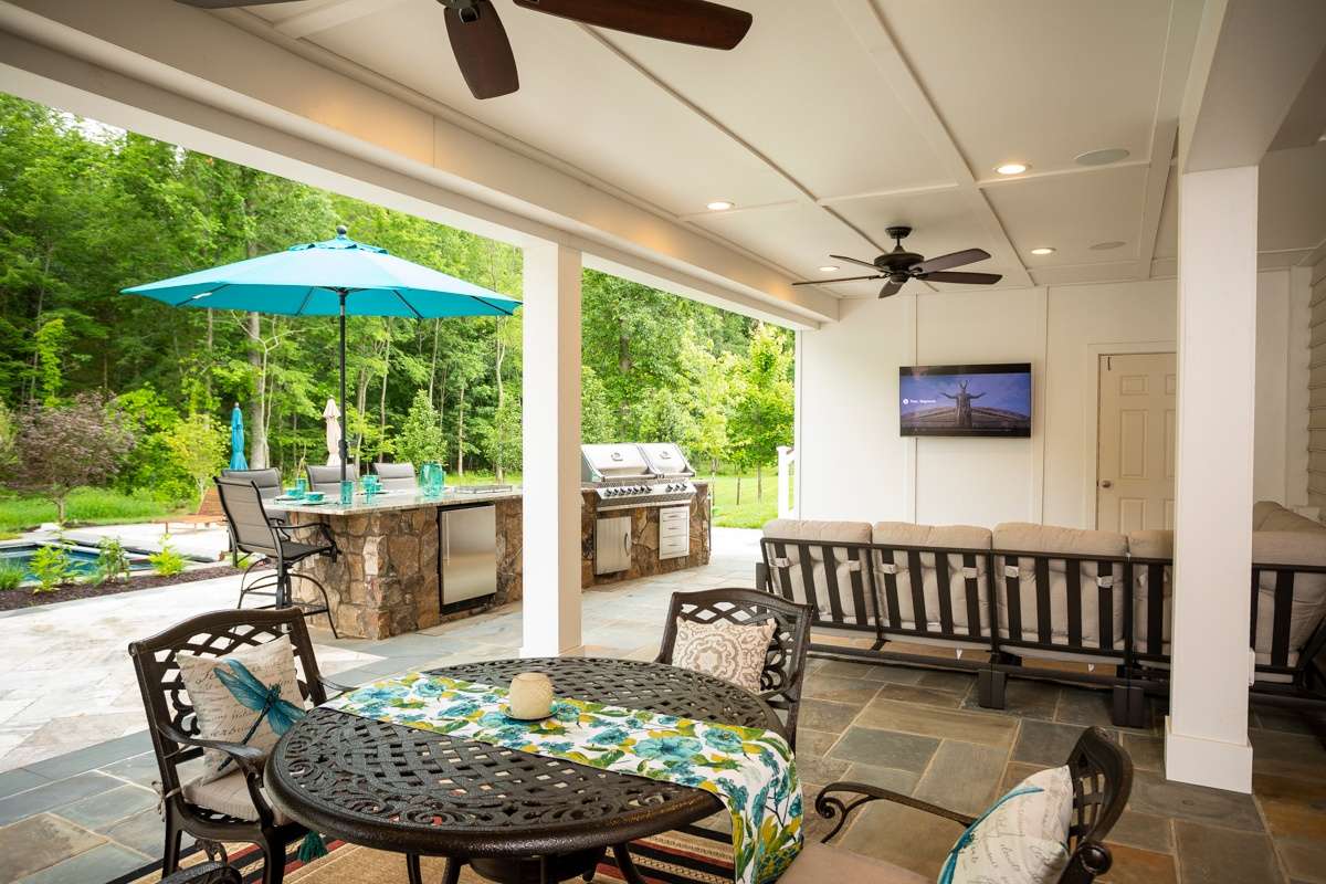 outdoor kitchen with tv and seating area