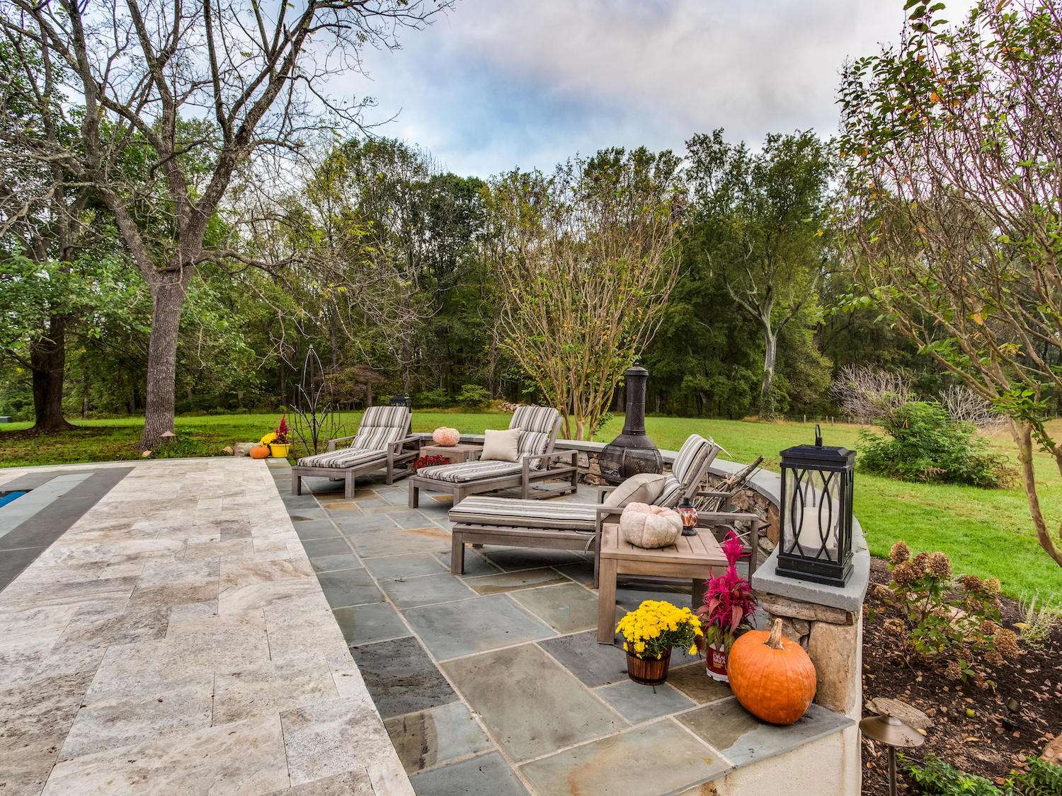 landscape patio with flagstone, plantings, and wall