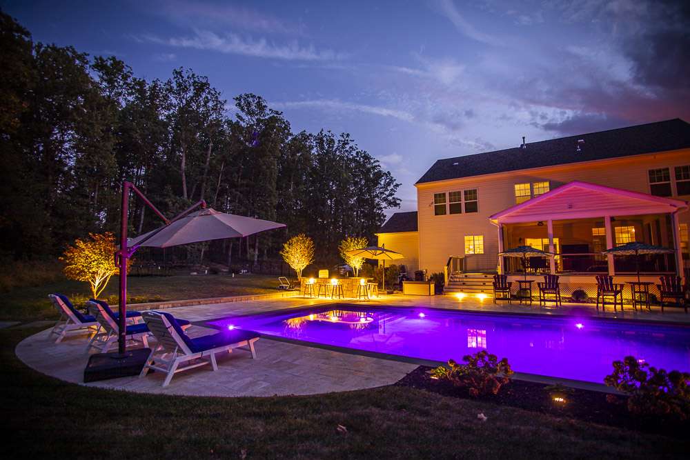 pool with outdoor seating area and lighting