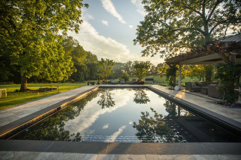 saltwater pool with pergola and trees