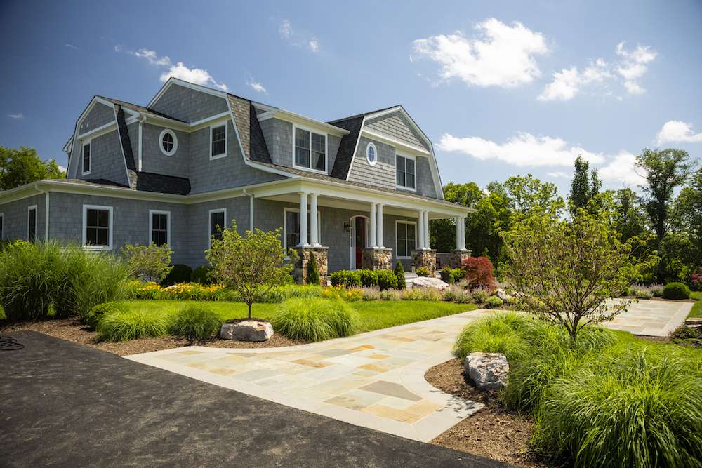 natural stone walkway with trees and plantings at front of home