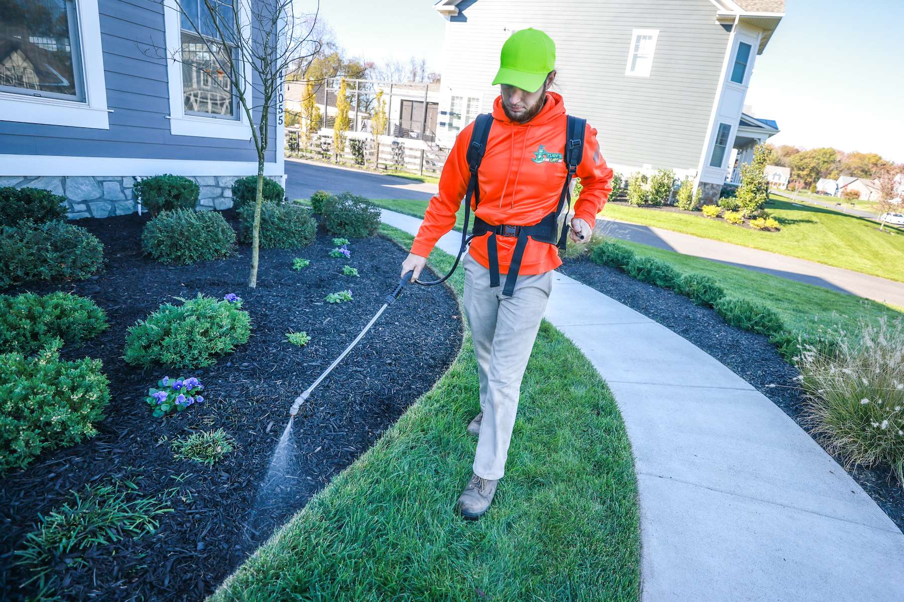 lawn care technician spot spraying weeds